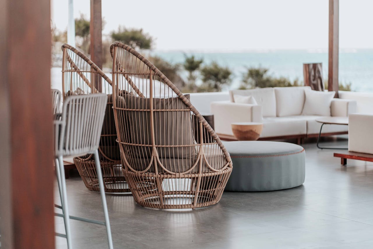 Stylish outdoor terrace featuring wicker chairs and sofas by the sea.